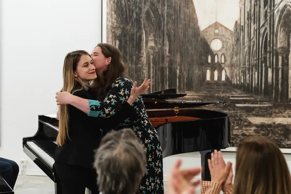 Twee musiciennes omhelzen elkaar na afloop van een concert.